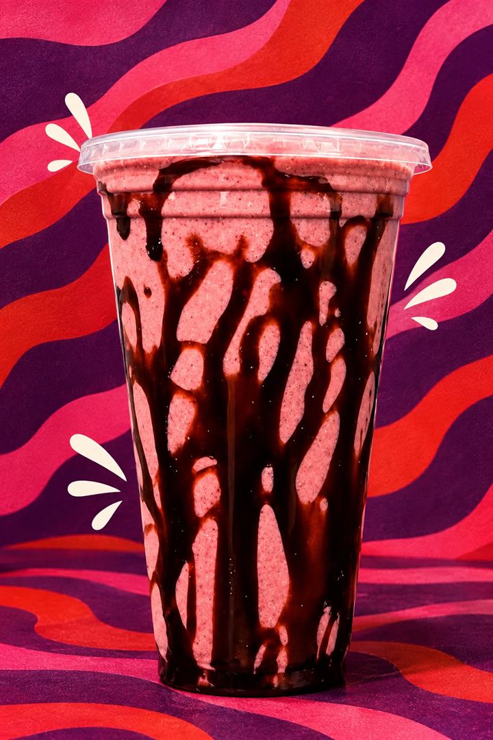 Copo de frapê de açaí com calda de chocolate escorrendo